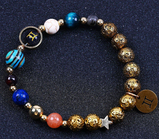 Beaded bracelet with blue, red, and gold beads; round zodiac charm and star accent.