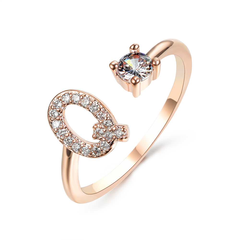 Rose gold adjustable initial ring with two-loop letter shape and round center stone.