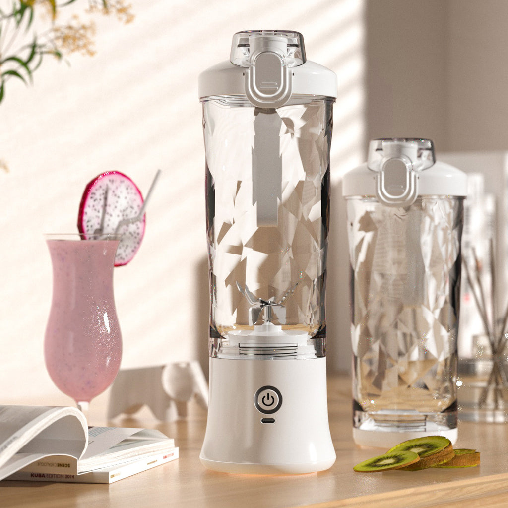 Portable blender with clear blending bottle and white base, shown with juice drink and glass