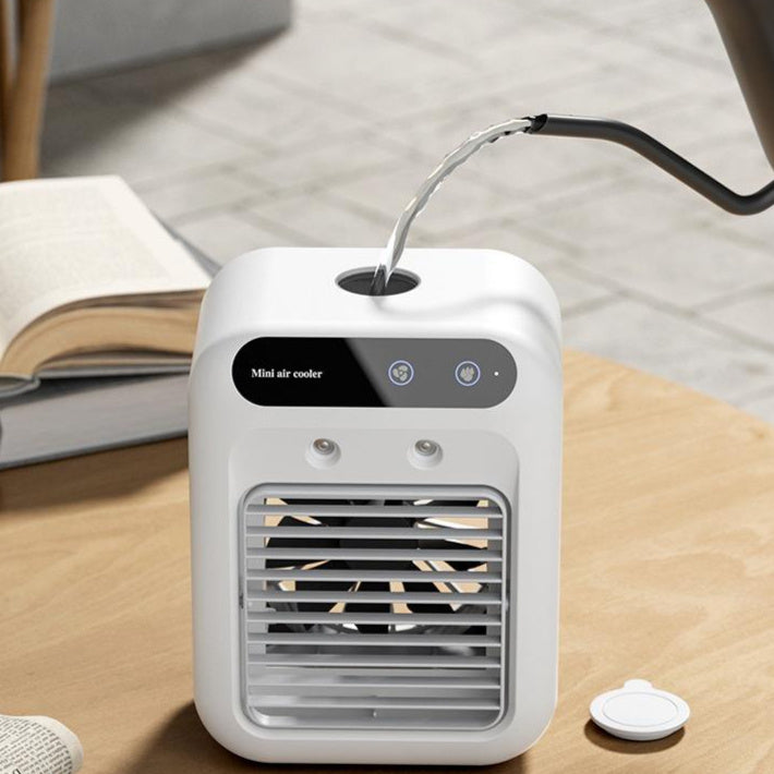 Portable mini air cooler on table with water stream routed into top inlet, white