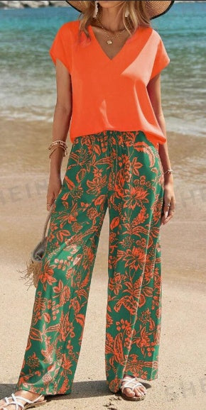 Orange V-neck short-sleeve top paired with green botanical wide-leg pants