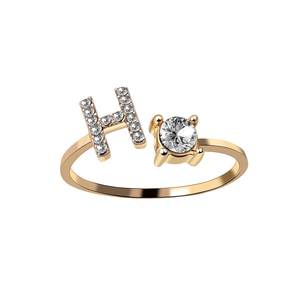 Gold adjustable initial letter ring with pave letter detail and oval center stone.