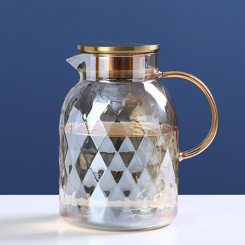 Glass cold water bottle with faceted diamond pattern and gold-tone lid, curved handle