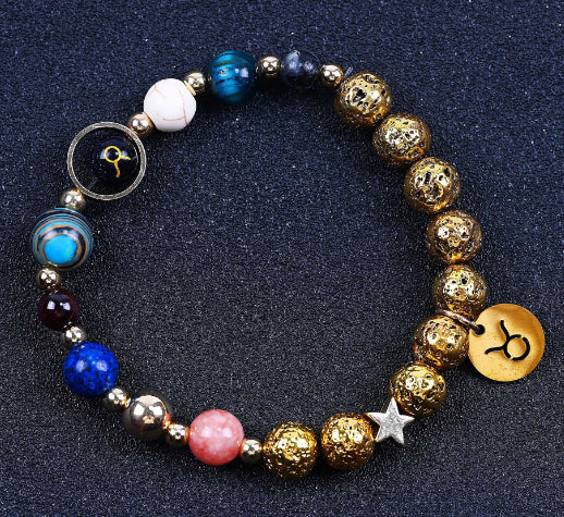 Beaded bracelet with blue, red, and gold beads; round zodiac charm and small star detail.