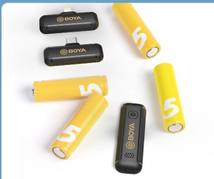 Clip-on BOYA radio microphone transmitter set with yellow batteries and black mic