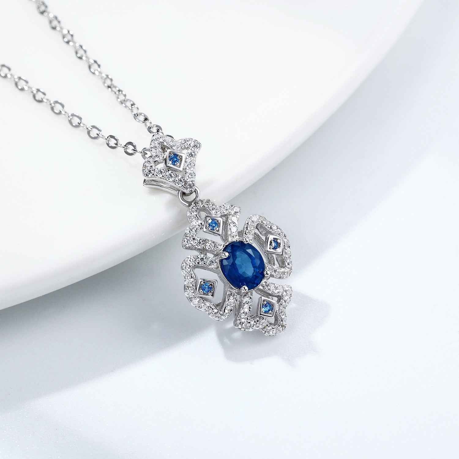 Silver necklace with blue sapphire cluster pendant and square halo stones