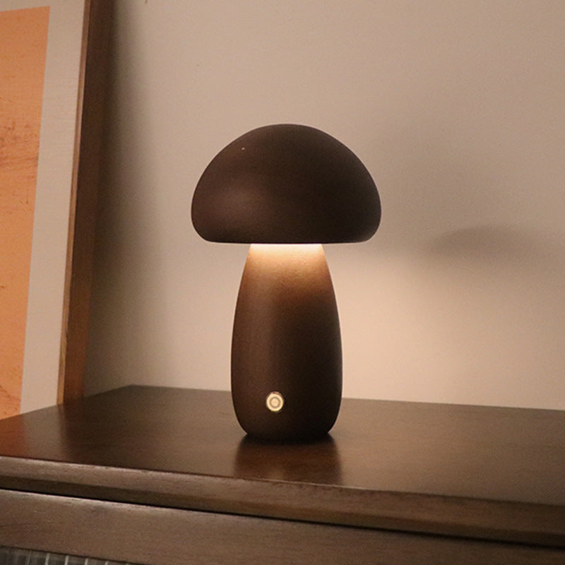 Dark wooden mushroom LED night light on a cabinet shelf, warm light glowing