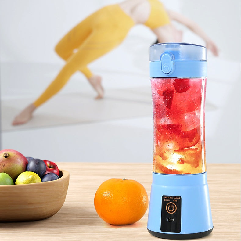 Blue portable electric fruit juicer with red smoothie in clear blending cup