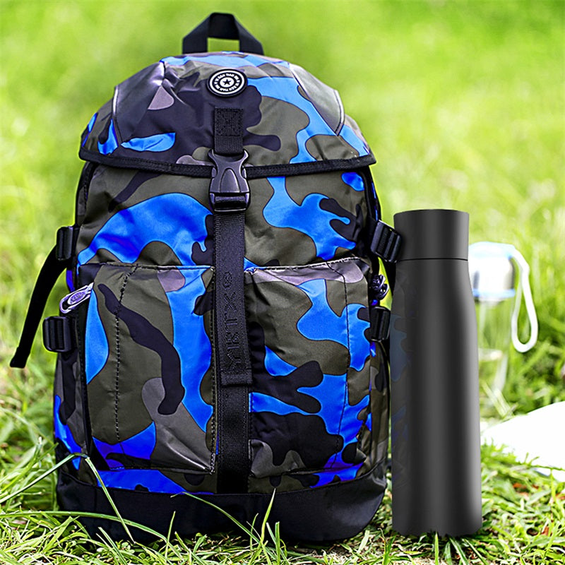 Black insulated thermal water bottle tumbler next to a blue patterned backpack