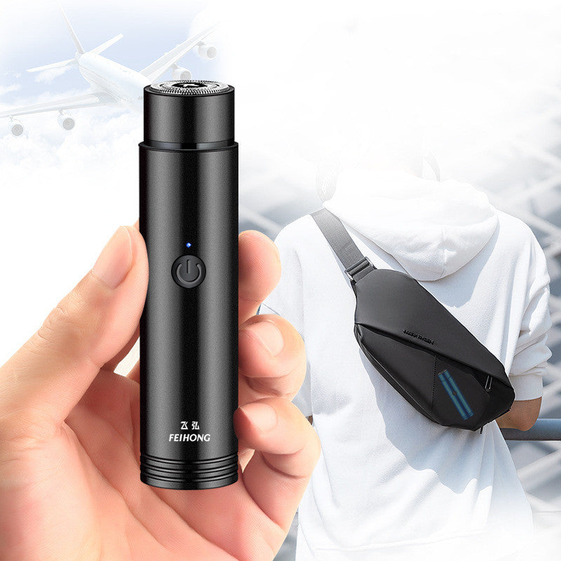 Black portable electric mini shaver with foil head and front power button.