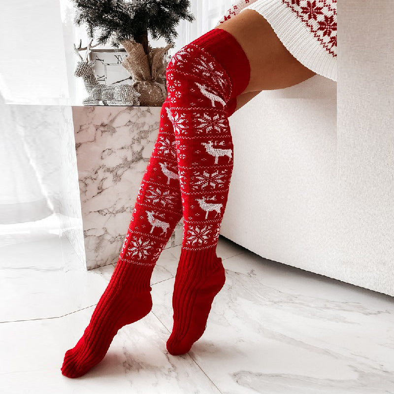 Red over-the-knee knit socks with white reindeer, snowflake, and Christmas motifs