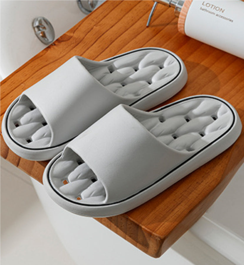 Light gray open-toe slide slippers with thick sole and molded cushioned footbed.