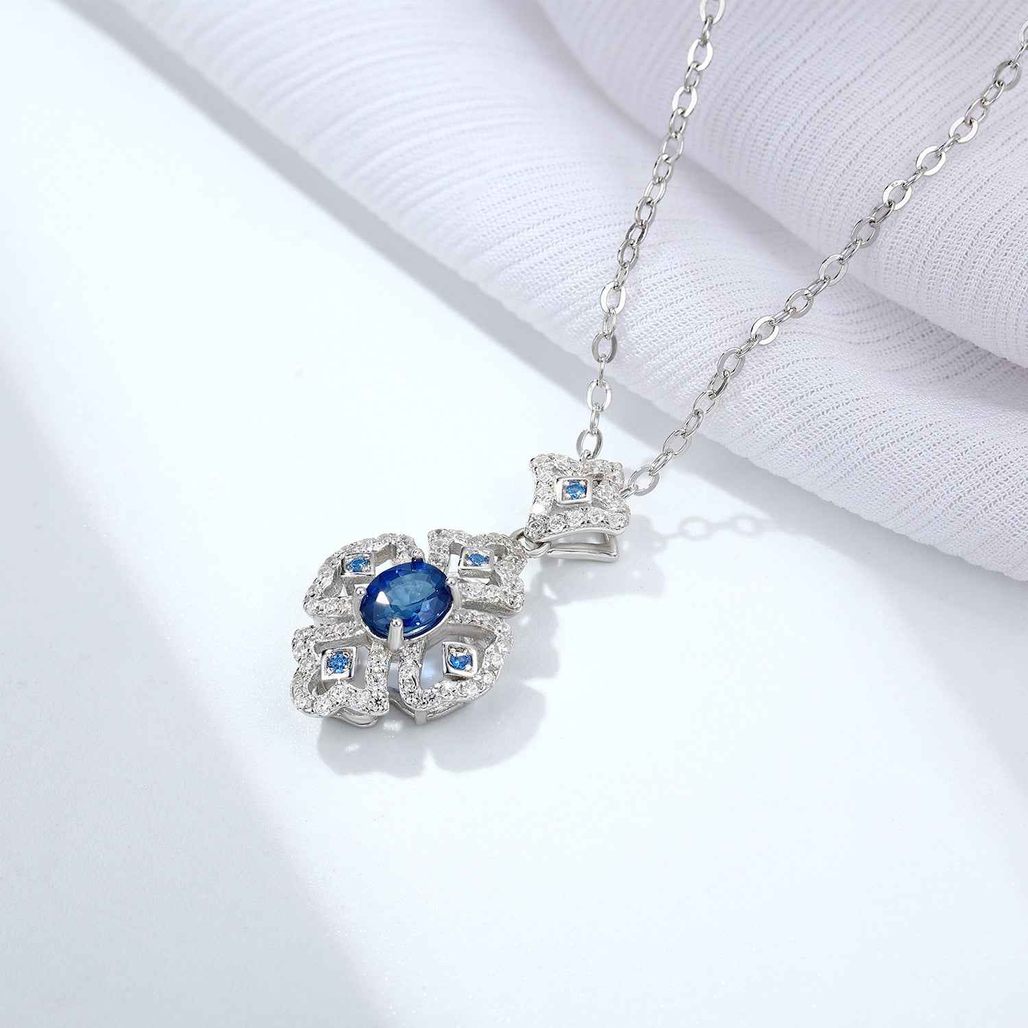 Silver necklace pendant with blue sapphire cabochon and square blue settings