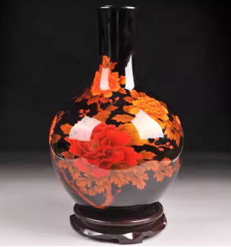 Ceramic bottle vase with orange-red floral motif and dark neck, round pedestal base