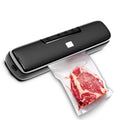 Black vacuum food sealer sealing a bag with sliced raw meat