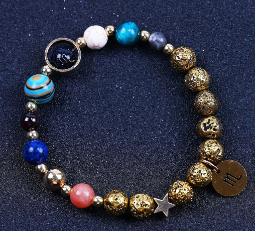 Beaded bracelet with blue, red, and gold beads; round zodiac charm and small star pendant.