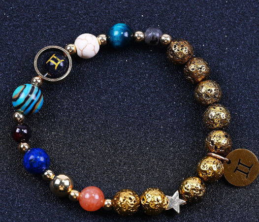 Beaded bracelet with blue and gold beads; circular zodiac charm, star charm, and mixed beads.